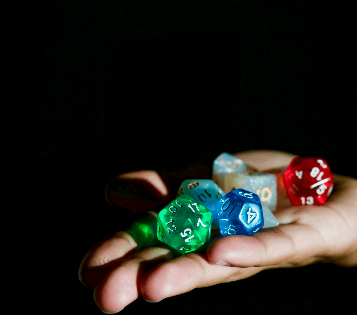 A hand holding a set of polyhedral dice.